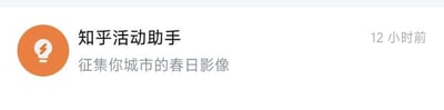 这是知乎官方账号「知乎活动助手」发布的活动通知截图，界面左侧是带有白色灯泡图标的橙色圆形标识，右侧依次展示账号名称「知乎活动助手」、发布时间「12小时前」，以及核心活动内容「征集你城市的春日影像」。整体UI设计简洁清晰，以图文结合的形式，号召知乎用户分享自己所在城市的春日相关影像内容，属于平台发起的用户内容征集类通知。