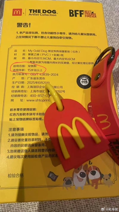 这是一张实拍的麦当劳与THE DOG艺术家系列联名宠物周边的图片，背景为黄色的产品包装盒，盒上印有联名标识、安全警告、产品参数、使用说明等文字内容，其中参数栏的「适用范围：宠物狗」与「适用年龄：15岁及以上」两行文字被红圈标注，二者并列容易让读者误解为要求宠物狗年龄满15岁才能使用，形成了错位的趣味笑点；盒旁摆放着红色的联名款狗狗项圈实物，带有醒目的黄色麦当劳金拱门标志，包装盒右下角还有卡通小狗插画，图片右下角带有作者水印「@拓海菌」。