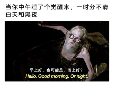 这是一张用来调侃大众午睡醒后混淆昼夜状态的搞笑梗图。图片上方配有简体中文文字“当你中午睡了个觉醒来，一时分不清白天和黑夜”，点明了梗图的核心场景；中间是截取的电影《未来水世界》中的画面，画面里一位面容憔悴、戴着大圆形眼镜的枯瘦老人身处昏暗环境中，一只手臂抬起，身体前倾，眼神迷茫困惑；画面下方配有该角色的台词“早上好，也可能是，晚上好？”，同时附带英文翻译，精准地传递出醒来后对当下时间完全不确定的迷惑感，能够引发有类似午睡后时空错乱经历的人的强烈共鸣。