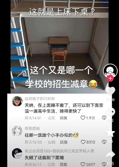 图片展示了一个极其狭小的宿舍空间，上铺床板下方放置了一张非常小的课桌，形成了一种滑稽的"上床下桌"布局。图片上方配有文字"这就是上床下桌？"，下方文字则调侃"这个又是哪一个学校的招生减章😂"，表达了对这种不合理宿舍设计的吐槽。图片下方还显示了几条网友评论，如"天呐，在上面睡不着了，还可以到下面重温一遍高中生活，睡得更快了"、"往那放跟个小手办似的😂"、"失眠了还能到下面睡"等，都是对这种狭小宿舍空间的幽默调侃。