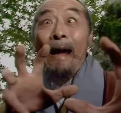 这是86版经典电视剧《西游记》的剧照截图，图中的土地公公双眼圆睁、嘴巴大张，露出极度惊恐的神情，双手向前伸出，身体前倾，仿佛正处于极度惊吓的状态。这个画面被网友截下做成表情包，常用来表达震惊、不敢相信、害怕的情绪，在社交平台聊天中广泛使用。