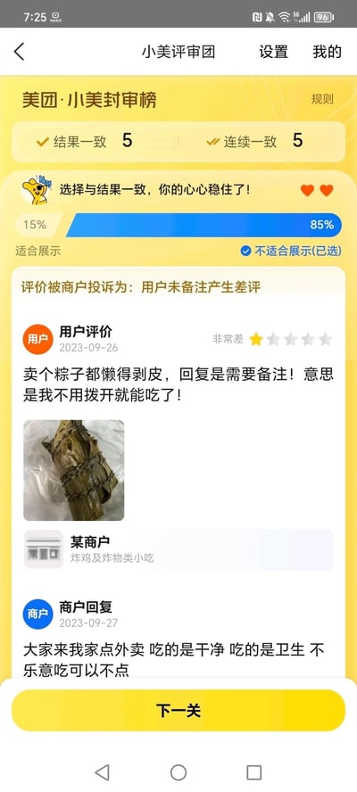 这是美团“小美评审团”的评价审核页面截图，页面顶部显示当前评审的结果一致次数为5，连续一致次数为5，系统提示“选择与结果一致，你的心心稳住了！”，进度条显示85%的评审选择“不适合展示”，当前已选该选项。本次审核的内容是一条被商户投诉的用户差评，投诉理由为“用户未备注产生差评”。用户于2023-09-26给出一星“非常差”的评价，内容为“卖个粽子都懒得剥皮，回复是需要备注！意思是我不用拨开就能吃了！”，并附带了一张未剥皮的粽子实物图；涉事商户为“某商户”，主营炸鸡及炸物类小吃，于2023-09-27回复用户“大家来我家点外卖 吃的是干净 吃的是卫生 不乐意吃可以不点”。