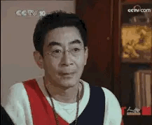 这是一张中央电视台《人物》栏目访谈的横屏截图，画面中的人物是演员章金莱（艺名六小龄童），他因饰演86版《西游记》中的孙悟空被全国观众熟知。画面里他穿着红白蓝拼接的上衣，佩戴项链，正处于讲话的状态，表情认真。画面左上角有CCTV台标，右上角有cctv.com标识，右下角标注了“人物”栏目标识，整体场景为室内访谈环境。