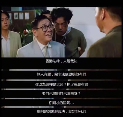 这是一张香港电影的截图，画面中一位身着浅色西装、戴着眼镜的男子面带笑容，正与对面的人交谈，他身后还站着几位男子。下方的字幕内容围绕香港法律的无罪推定原则展开，该角色正在就相关内容与对方进行争辩。