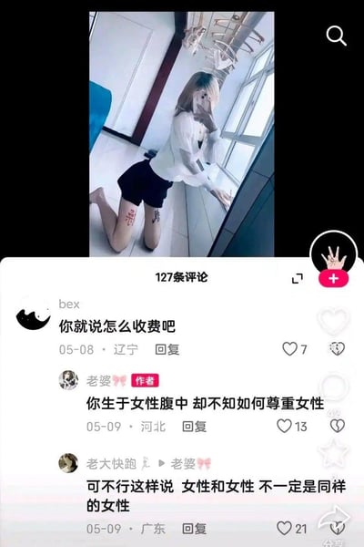 这是一张抖音竖屏截图，上方是一位跪地对着镜子自拍的女生，她的双膝分别纹有“病”“毒”字样；下方是该内容的评论区互动：辽宁用户“bex”留言“你就说怎么收费吧”，对女生进行恶意揣测，发布该内容的作者（河北用户“老婆”）回怼“你生于女性腹中 却不知如何尊重女性”，随后广东用户“老大快跑”回复作者“可不行这样说 女性和女性 不一定是同样的女性”，这条评论获得21个赞，整个场景呈现出网络上关于女性尊重的争议性对话，反映了部分网友对女性的恶意揣测以及不同的观点碰撞。
