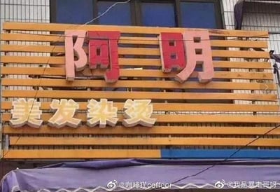 这是一张街边美发店的招牌实拍图，招牌以木质条状结构作为背景，上方是红底白边的立体“阿明”二字，下方是浅金色立体的“美发染烫”字样，清晰标注了店铺名称和经营业务，图中没有谐音梗、双关或暗示类内容。