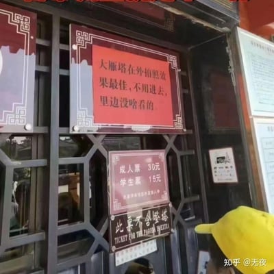 这是一张拍摄于西安大雁塔售票亭的实拍图，最醒目的是上方红色标语写着「大雁塔在外拍照效果最佳，不用进去，里边没啥看的」，下方则标注着成人票30元、学生票15元的票价信息，还补充说明此票不含登塔。这种与常规景点售票逻辑完全相反的耿直标语，和售票的本职工作形成强烈反差，显得格外诚实有趣，让游客忍俊不禁。