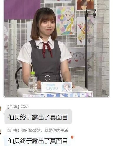 这张图是直播画面与评论区的图文混排内容，画面主体是活跃在日本的中国籍声优Liyuu，她身着白衬衫搭配灰色背心裙，系着红色领结，面带微笑坐在桌前，桌上摆放着写有“Liyuu”的名牌和一瓶带吸管的透明饮品，背景是贴有多张动漫海报的布景。下方是观众的评论内容，包含标注【活肤】的“鸡い”、标注【吐槽】的“你所热爱的，就是你的生活”，以及两条重复的“仙贝终于露出了真面目”，其中“仙贝”是粉丝对Liyuu的爱称“鲤鱼仙贝”的简称，属于粉丝玩梗的内容。