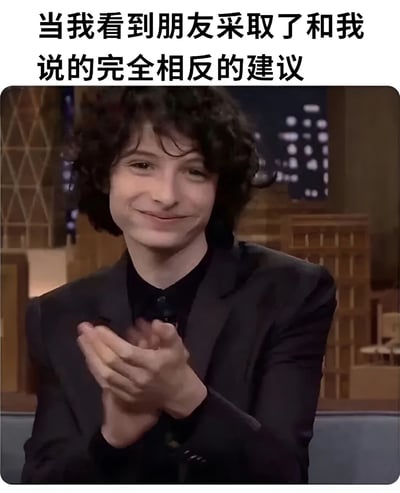 图片上方有文字“当我看到朋友采取了和我说的完全相反的建议”，下方是一位卷发男子穿着黑色西装，面带微笑地鼓掌。这个表情包通常用于表达当朋友不听从自己建议时的无奈又好笑的心情。