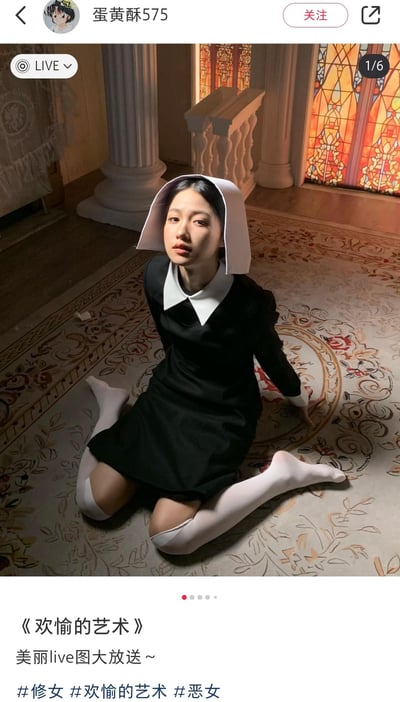这是社交媒体用户发布的live动态写真图，图中女生身着修女风格服饰：黑色连衣裙搭配白色大翻领，头戴简易款修女帽，跪坐在带有复古花纹的地毯上，身体向后用手支撑，直视镜头，面部带着清冷的神情。背景是仿欧式教堂的场景，有罗马柱和暖色调的彩色玻璃窗，整体氛围复古又带着疏离感。配文标注为《欢愉的艺术》，说明是美丽live图的分享内容。