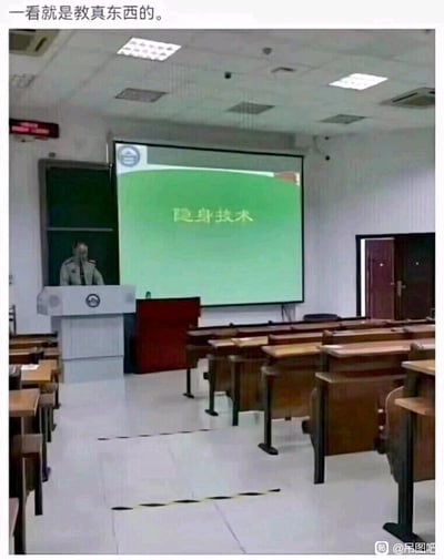 这是一张趣味梗图，画面呈现了一间空荡荡的大学教室，讲台上站着一位神情平静的老师，前方的投影屏幕上清晰显示着课程标题“隐身技术”。图片顶部配有文字“一看就是教真东西的”，通过“隐身技术”的课程主题与空无学生的教室场景形成巧妙呼应，玩了一个场景梗——仿佛学生们都已经掌握了隐身技术，或是老师用这种极端的方式来直观演示隐身的概念，营造出荒诞又搞笑的反差效果，让人忍俊不禁。