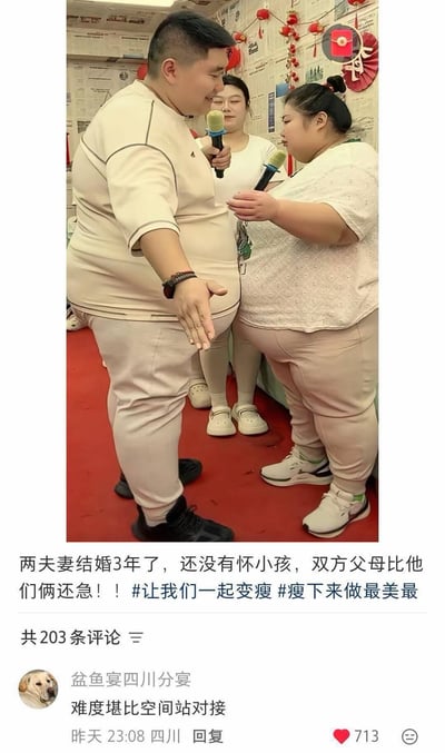 这是一张竖版的社交媒体截图，图片主体部分是三位人物：一对体型偏胖的夫妻站在前侧，两人都手持麦克风，男方面带微笑伸出手做出手势，女方面向男方持麦克风站立，另一位女性站在二人后方；背景墙面贴满报纸，还装饰有红色新年挂饰，地面铺设红色地毯。图片下方配文说明这对夫妻结婚三年没有怀孕，双方父母比他们更着急，附带了减肥相关的话题标签，标注共有203条评论。第一条热评由用户“盆鱼宴四川分宴”发布，内容为“难度堪比空间站对接”，该评论获得713个赞，评论暗指夫妻二人身材都偏胖，受孕难度高，形成了这个图的核心笑点。