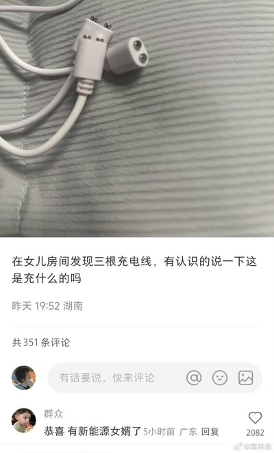 这是一张社交媒体截图，分为上下两部分：上半部分展示了三根特殊的充电线，其中两个为金属公头、一个为母头，外观不同于普通电子设备的充电线；下半部分是一位湖南用户发布的求助内容，配文“在女儿房间发现三根充电线，有认识的说一下这是充什么的吗”，发布时间标注为昨天19:52。下方有一条获2082个赞的高赞评论，来自广东用户，内容为“恭喜 有新能源女婿了”，此处玩了隐晦的谐音梗，用“新能源”暗指这类充电线是成人情趣用品的充电线，通过调侃的方式回应求助，制造出搞笑又略带尴尬的效果。