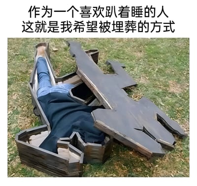 图片上方配有文字'作为一个喜欢趴着睡的人 这就是我希望被埋葬的方式'，下方是一张实拍照片：一名穿着蓝色牛仔裤和深色上衣的人趴在一个破损的棺材里，棺材放置在草地上，棺盖断裂并歪斜地盖在身上，整体通过夸张的方式将趴着睡的习惯幽默化地延伸到对埋葬方式的调侃，充满黑色幽默。
