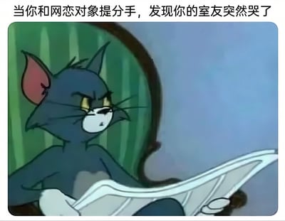 图片中是《猫和老鼠》里的汤姆猫，它坐在椅子上，双手拿着报纸，表情愤怒且带着怀疑，耳朵竖起，眼神锐利。图片上方配有文字“当你和网恋对象提分手，发现你的室友突然哭了”，通过汤姆猫的表情营造出一种搞笑的反转场景，暗示室友可能就是那个网恋对象，从而产生幽默效果。