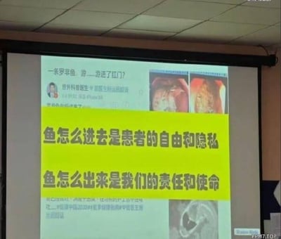 图片展示了一个医疗会议的投影屏幕，上面显示了一个关于"罗非鱼游进肛门"的病例讨论。屏幕上方有医生的名字和标题，中间是问题和几张内窥镜检查图像，下方有一条醒目的黄色标语写着："鱼怎么进去是患者的自由和隐私 鱼怎么出来是我们的责任和使命"。整个画面呈现了医疗工作者面对特殊病例时的专业态度与幽默感。