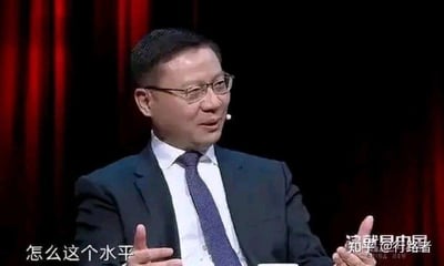 这是一张出自政论节目《这就是中国》的视频截图，图中人物为学者张维为，他身着深色西装、白衬衫搭配深蓝色领带，戴着眼镜，双手摊开，面部神态带着明显的质疑与不解。画面左下角配有白色字幕‘怎么这个水平’，右下角标注有节目名称‘这就是中国’以及知乎用户@行路者的水印。这张截图被制作成表情包后，常被用于社交场景中，表达对人或事物的水平感到失望、质疑的情绪，没有双关或谐音梗的设计。