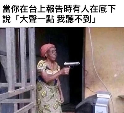 这是一张经过文字加注的静态梗图，画面上方配有文字“当你在台上报告时有人在底下说「大声一点 我听不到」”，图中主体是一位穿着带有圆形图案的花色服饰、戴着粉色头巾的老年女性，她表情严肃，正举着手枪指向画面外。这张图用夸张的暴力姿态，来调侃人们在台上进行公开报告时，被台下听众突然要求“大声点”的烦躁与愤怒情绪，将这种职场中常见的小矛盾用极具冲击力的画面表现出来，达到搞笑宣泄的效果，属于职场类的搞笑梗图。