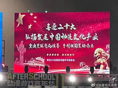 这是青岛AS动漫游戏嘉年华（又名AFTERSCHOOL11动漫游戏嘉年华）的现场主屏幕实拍图。屏幕以鲜艳的红色为底色，搭配五角星、华表、天安门、石狮子、长城等具有中国特色的标志性元素，营造出庄重正式的氛围。屏幕上的核心文字内容围绕主旋律主题展开，包括“喜迎二十大 弘扬发展中国动漫文化产业 坚决紧跟党的领导 争创祖国美好未来”，下方还有“奋进新征程、建功新时代”以及“青岛AS动漫游戏嘉年华组委会”的字样。屏幕下方的舞台区域清晰标注了“AFTERSCHOOL11 动漫游戏嘉年华”的活动名称，将动漫游戏主题的线下活动与正能量宣传内容相结合，呈现出独特的活动宣传风格。
