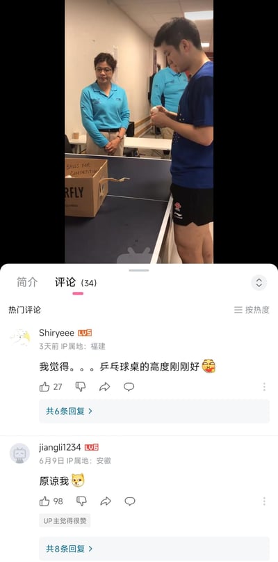 这是一张B站的视频截图，画面中乒乓球运动员樊振东站在乒乓球桌旁，由于桌子的位置和拍摄角度，形成了视觉错位，看起来樊振东的下半身和桌后女士的身体衔接在了一起，制造出滑稽的视觉效果。评论区的网友留言“我觉得。。。乒乓球桌的高度刚刚好”“原谅我”，都是在调侃这个搞笑的视觉错觉。
这是利用视觉错位制造的搞笑梗，通过画面角度巧合形成误解，引发网友玩梗。