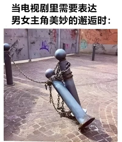 这是一张幽默梗图，通过视觉比喻讽刺电视剧中常见的“男女主角美妙邂逅”套路。图片上方配有文字“当电视剧里需要表达男女主角美妙的邂逅时：”，下方则是一张实拍照片——两根金属路桩被铁链连接，其中一根倾斜并倚靠在另一根上，造型酷似一对亲密相拥的情侣。背景是布满彩色涂鸦的墙面和石板地面，增强了 urban 场景的真实感。整体通过日常物体的意外组合，以荒诞又形象的方式解构了影视剧中的浪漫化邂逅桥段，引发观众共鸣和笑点。