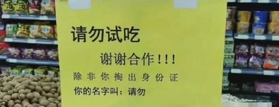 这是一张在超市干货区域拍摄的静态照片，画面主体是一张张贴的黄色告示牌。告示牌上的文字采用了无厘头的文字梗设计，先是以常规的警示语气写着“请勿试吃 谢谢合作！！！”，随后笔锋一转补充道“除非你掏出身份证 你的名字叫：请勿”，将“请勿试吃”短语里的“请勿”单独抽离出来作为人名，制造出一种逻辑上的趣味陷阱，用幽默搞笑的方式来提醒顾客不要试吃商品。告示牌的周围可以看到货架上摆放着各类包装食品，下方还有散装的干货商品，场景明确是超市的购物区域。