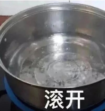 这是一张文字加注的静态单图，画面展示了一口放在炉灶上的不锈钢锅，锅内的水正处于沸腾状态，水面有明显的翻滚波纹和气泡。图片底部配有白色的“滚开”二字，运用了双关的修辞手法：“滚开”字面意思是描述水沸腾翻滚的状态，同时在中文口语里，“滚开”也是带有情绪色彩的、让他人离开的表述，通过这种双关的方式，将日常烧水的场景和口语化的诉求结合，制造出幽默搞笑的效果，适合用来以调侃的语气表达让他人远离的想法。