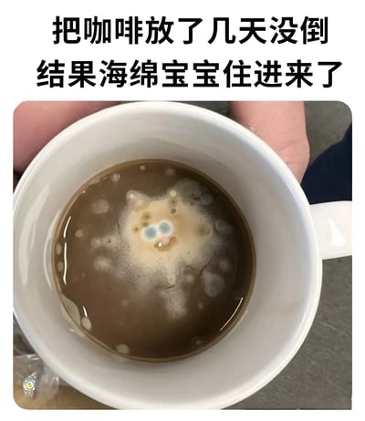 图片展示了一只白色咖啡杯，杯中残留着放置多日未清理的咖啡，液体表面已滋生出霉菌。有趣的是，霉菌的形状神似卡通角色海绵宝宝，中间有两个蓝色斑点如同眼睛，整体造型十分滑稽。图片上方配有文字“把咖啡放了几天没倒 结果海绵宝宝住进来了”，通过幽默的方式将霉菌的外形与海绵宝宝联系起来，制造出令人捧腹的效果。