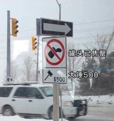 这是一张在冬季积雪户外拍摄的道路场景图，画面中心是一组交通标志：上方是带有红色禁止圈的标志，其图案被网友视觉联想为罐头，配文‘罐头已售罄’；下方是带有锤子图案和$500字样的标志，配文‘大锤500’，结合了小品《装修》里的‘大锤’梗制造搞笑效果。背景可见行驶的白色SUV、交通信号灯、积雪的树木，整体是国外冬季道路的真实场景，通过对交通标志的趣味解读和文字加注，形成了反差感十足的搞笑梗图。