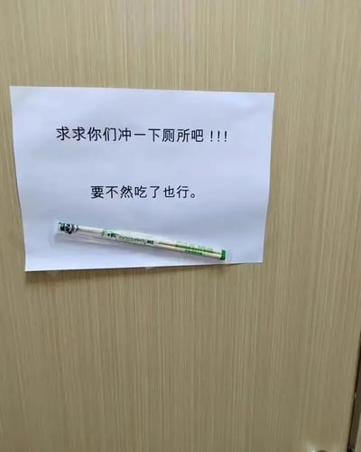 图片展示了一张贴在木质墙面上的白色便签纸，上面用黑色字体手写着两行文字：第一行为“求求你们冲一下厕所吧 !!!”，表达了强烈的恳求语气；第二行为“要不然吃了也行。”，以极端讽刺的方式吐槽公共厕所中有人使用后不冲水的不文明行为。便签纸下方放着一支带有绿色图案的白色笔，整体场景像是办公室、宿舍或公共卫生间等共享空间，通过黑色幽默的文字引发对公共卫生礼仪的共鸣与调侃。