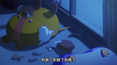 动画场景中，一个黄色圆形角色带有粉色条纹，躺在地板上，身上有破损，白色填充棉从破口处露出。旁边散落着一些填充棉和一个破损的部件。场景整体呈现蓝色调照明，底部有字幕"别說了别說了别說了"。