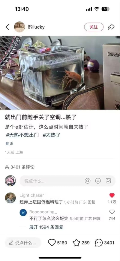 社交媒体用户“韵lucky”发布的图文内容，展示了一个透明鱼缸，里面有一只虾漂浮在水中，配文称出门前随手关了空调，回来发现虾“熟了”，调侃是“e虾”（谐音“易虾”）且“自来熟”，幽默吐槽天气炎热。画面中鱼缸放置在木质桌面上，旁边有电子设备和小摆件，整体氛围轻松搞笑。