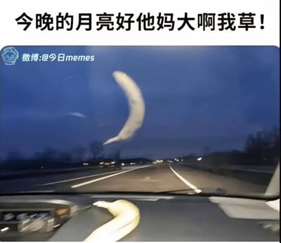 图片上方配有夸张感叹文字“今晚的月亮好他妈大啊我草！”，主体为汽车驾驶视角的夜景：前方道路延伸至远方，深蓝色天空下，仪表盘上的香蕉因近大远小的视觉错位，在车窗外背景中看起来像一轮巨大弯月，形成“误把香蕉当月亮”的搞笑效果。