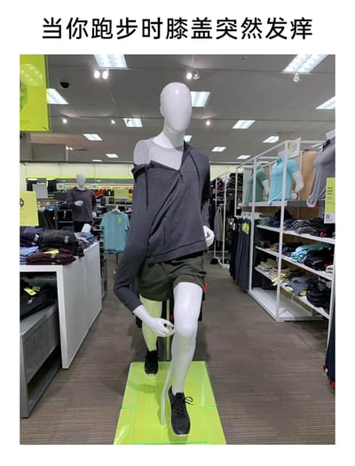 这是一张加注了文字的实拍趣味照片，拍摄场景为运动服饰店内。前景的人体模特被摆出跑步途中弯腰挠膝盖的姿势，由于这个动作，模特身上的上衣被拉扯得错位滑落，呈现出滑稽的状态。上方的文字“当你跑步时膝盖突然发痒”精准地将模特的姿态与人们日常跑步时遇到的尴尬小窘境联系起来，用夸张的视觉效果放大了这种日常经历的趣味性，让人产生共鸣。