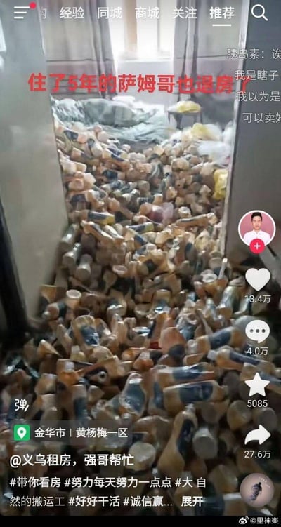 这是一张抖音租房短视频的截图，画面中是租客萨姆哥住了5年后退房的房间，整个房间被数量惊人的空啤酒瓶堆满，几乎看不到原本的房间布局，视觉冲击力极强。画面上方配有红色文字“住了5年的萨姆哥也退房了”，右侧是抖音的互动数据：点赞13.4万、评论4.0万、收藏5085、转发27.6万。左下角定位为金华市黄杨梅一区，发布账号为@义乌租房，强哥帮忙，附带多个租房相关的话题标签。右侧评论区有网友调侃的内容，如“我是瞎子”“可以卖好”，整体场景充满猎奇感，让人对租客的生活习惯感到震惊，同时也成为租房类内容的吸睛素材。