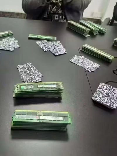 这张图呈现了一个充满脑洞的趣味场景：人们将电脑内存条替代扑克牌，在会议桌上摆出类似打牌的布局，背景中可见参与的真人。这种将硬件产品与日常娱乐结合的玩法，精准戳中了程序员、硬件爱好者的笑点，充满了新奇的创意感。