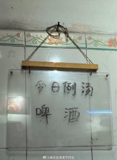 这是挂在瓷砖墙面上的一块透明手写告示牌，上方写着“今日例汤”，下方却写着“啤酒”，用啤酒当例汤，是店家的搞笑整活，反差感拉满，让人觉得有趣又离谱。