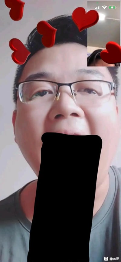 这是一张经过图像编辑软件改编的恶搞图片，主体是一位戴眼镜的真人男性，嘴巴位置被黑色长条遮挡，营造出长嘴的视觉错觉，画面上方添加了红色爱心特效，右上角还有一小部分人物画面，整体走趣味恶搞的风格，没有双关、谐音梗或暗示内容。