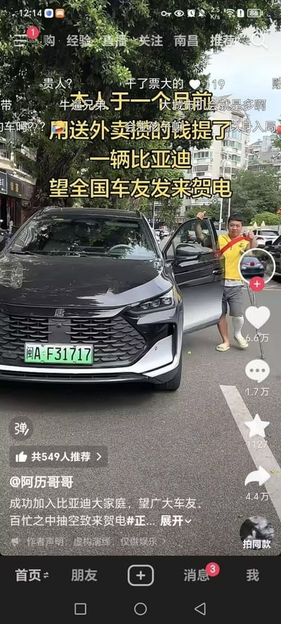 这是一张抖音短视频的竖屏截图，画面主体是一辆悬挂闽A绿色新能源牌照的黑色比亚迪唐汽车，旁边站着一名穿黄色外卖工服、腿部打石膏的男子，他打开车门举起双手做出庆祝姿态。画面叠加黄色醒目大字说明博主称自己一个月前用送外卖攒的钱提了这辆比亚迪，希望全国车友发来贺电，底部配文也标注了同样的诉求，同时作者标注内容为虚构演绎仅供娱乐。界面保留了抖音的完整交互元素，右侧可见点赞、评论、转发等互动数据，顶部还有其他用户发送的弹幕内容。