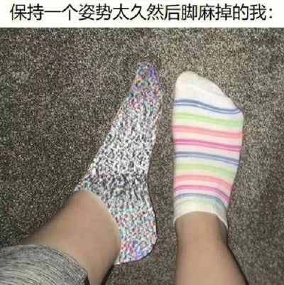 图片展示了一个人因长时间保持同一姿势而脚麻的场景。画面中可以看到一双穿着不同花纹袜子的脚，一只袜子是彩色斑点图案，另一只则是彩虹条纹图案，双脚平放在地毯上，暗示着主人正经历脚麻的不适感。图片上方配有文字"保持一个姿势太久然后脚麻掉的我:"，以幽默的方式表达了人们日常生活中常见的小困扰。