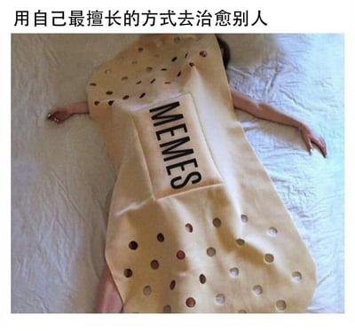 这是一张创意治愈系MEMES图，画面中一名真人躺在床上，身体被设计成大号创可贴样式的毯子完全覆盖，仅露出头部的一小部分和两只摊开在身体两侧的手臂。毯子的中央印有英文“MEMES”字样，图片顶部配有中文文字“用自己最擅长的方式去治愈别人”。整幅图将MEMES（网络梗图、趣味段子）比作能够疗伤的创可贴，寓意着这类网络趣味内容能够凭借自身的搞笑属性，为人们带来欢乐，抚平负面情绪，以擅长的方式为他人提供情绪慰藉。