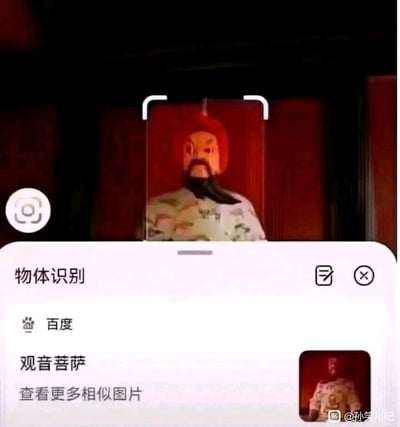 这是一张手机设备界面的静态截图，画面上半部分展示了一尊塑像，该塑像头戴红色帽子，留着黑色长胡须，身着带有花纹的传统服饰，外观风格类似关公或古代官员，呈静止立姿，面容严肃；画面下半部分是百度物体识别的功能界面，界面显示识别结果为“观音菩萨”，还附带“查看更多相似图片”的选项。AI将风格完全不符的塑像错误识别为观音菩萨，这种明显的识别失误形成了强烈的反差，制造出搞笑的乌龙效果，属于网友分享的日常趣味失误事件。