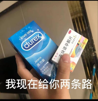 图片中一只手同时拿着两个物品：左侧是蓝色包装的杜蕾斯（Durex）避孕套，包装上印有“love sex”和“Jeans活力装”字样；右侧是白色包装的左炔诺孕酮片（紧急避孕药），标注为“紧急避孕1片装”。图片底部有醒目文字“我现在给你两条路”。

双关含义：“两条路”既指画面中展示的两种避孕产品，也隐喻在亲密关系中面临的不同选择——事前预防（避孕套）与事后补救（紧急避孕药）。