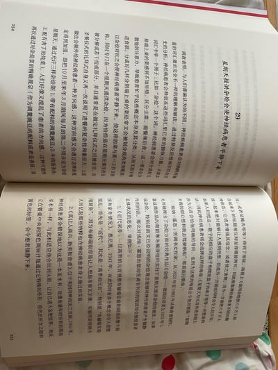 图片展示了一本打开的书籍内页，清晰呈现第254页和第255页的内容。页面布满密集的中文印刷文本，涉及神经症患者、荣格理论、历史年份（如1932年、1892年）等学术性话题。书籍放置在带有红、绿、蓝彩色圆点图案的布料表面，书页边缘整齐，无折痕或涂改痕迹，整体画面为自然光拍摄，色调柔和。
