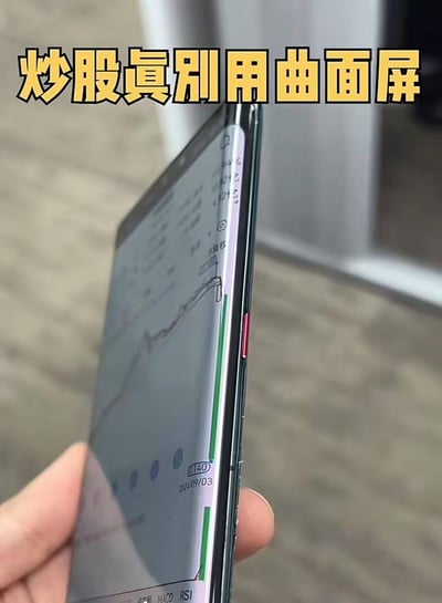 这张图从侧面拍摄一部曲面屏手机，屏幕显示着股票K线图，受曲面屏边缘的弯曲特性影响，原本正常的K线在屏幕边缘被“掰弯”，视觉上像是股价突然大幅下跌。图上方配有醒目的黄色文字“炒股真别用曲面屏”，精准吐槽了曲面屏在查看股票数据时的反人类设计，容易误导股民，用夸张的视觉效果展现了曲面屏在炒股场景的弊端，搞笑又扎心。