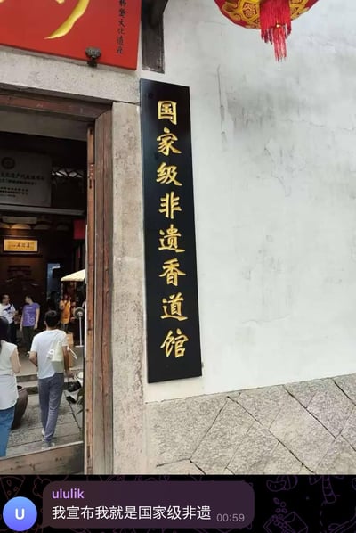 这张图由两部分组成：上半部分是实拍的国家级非遗香道馆门口，白墙灰石的古建外墙上挂着黑底金字的“国家级非遗香道馆”竖牌，门口有行人进出，场馆具有传统古建风格；下半部分是一段聊天截图，用户“ululik”发布消息“我宣布我就是国家级非遗”，借图中的牌匾玩梗，用幽默自嘲的方式调侃自己，制造出搞笑的效果。