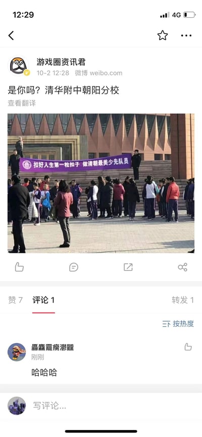 这是一张微博截图，微博用户“游戏圈资讯君”于10月2日12:28发布了清华附中朝阳分校的现场照片。照片里，学校广场上聚集着众多学生、教职工，建筑前悬挂着一条紫色横幅标语，原本应为“扣好人生第一粒扣子 做新时代最美少先队员”，却被错写成“扣好人生第一粒扣子 做清朝最美少先队员”，出现了明显的文字乌龙。评论区有用户发布“哈哈哈”的评论，对这一乌龙事件表示调侃。