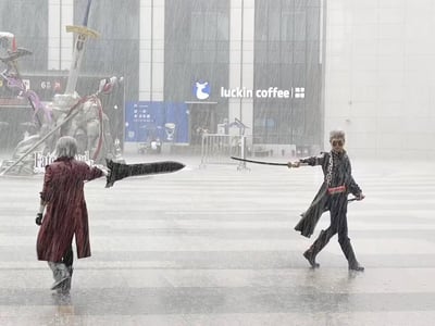 在瓢泼大雨的户外广场上，两位coser分别扮演游戏《鬼泣》中的但丁与维吉尔，手持还原的武器——叛逆大剑与阎魔刀，摆出对峙的战斗姿势。背景可见瑞幸咖啡门店与Fate相关的展架，滂沱大雨为整个场景增添了强烈的戏剧性，完美还原了游戏中兄弟对决的热血氛围。
