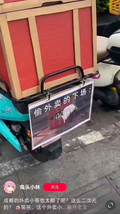 这是一张竖屏格式的社交媒体截图，内容展示了一位成都外卖小哥的创意整活：在自己的电动车外卖箱下方，悬挂了一块自制的警示标语牌，上方用黑色字体写着“偷外卖的下场：”，下方搭配了一张动漫《间谍过家家》中角色阿尼亚·福杰被卡在类似箱子空间里的截图，用二次元的趣味方式调侃、警告偷外卖的行为。截图左下角带有发布者“兔头小林”的标识，下方配文表示这位外卖小哥的行为十分“二次元”，让人觉得好笑又有创意。