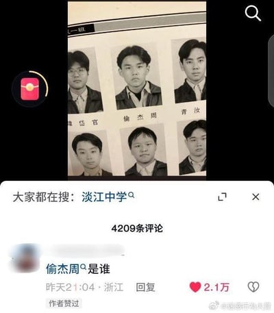 这是一张社交媒体截图，画面上方是淡江中学某班级的证件照页面，其中第二排第一个人物是周杰伦，他的名字被倒写为“倫杰周”；画面下方是评论区，一条获赞2.1万的评论将“倫”误看成“偷”，提问“偷杰周是谁”，形成谐音梗，制造出搞笑的效果。
- 谐音梗说明：将周杰伦的名字倒写为“倫杰周”，评论又将“倫”错看成“偷”，衍生出“偷杰周”的趣味说法，调侃了这个被倒写的名字。
